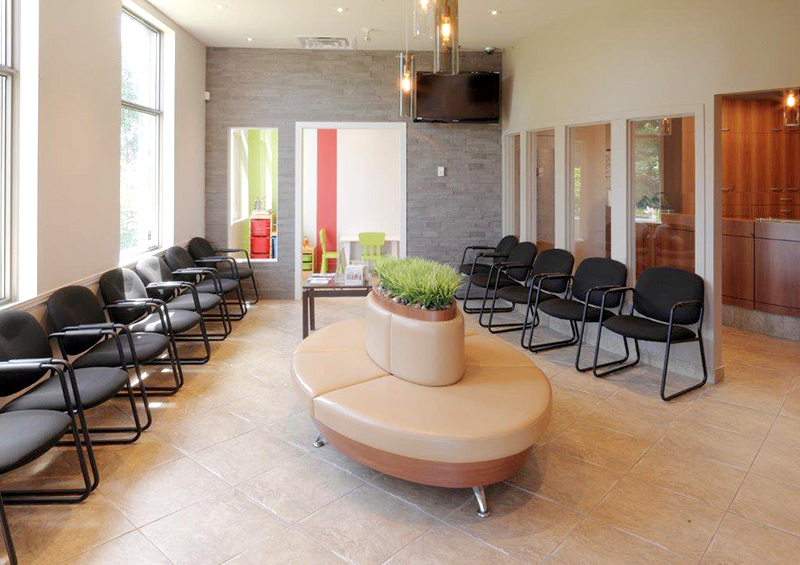 Salle d’attente moderne et lumineuse d’un centre dentaire.