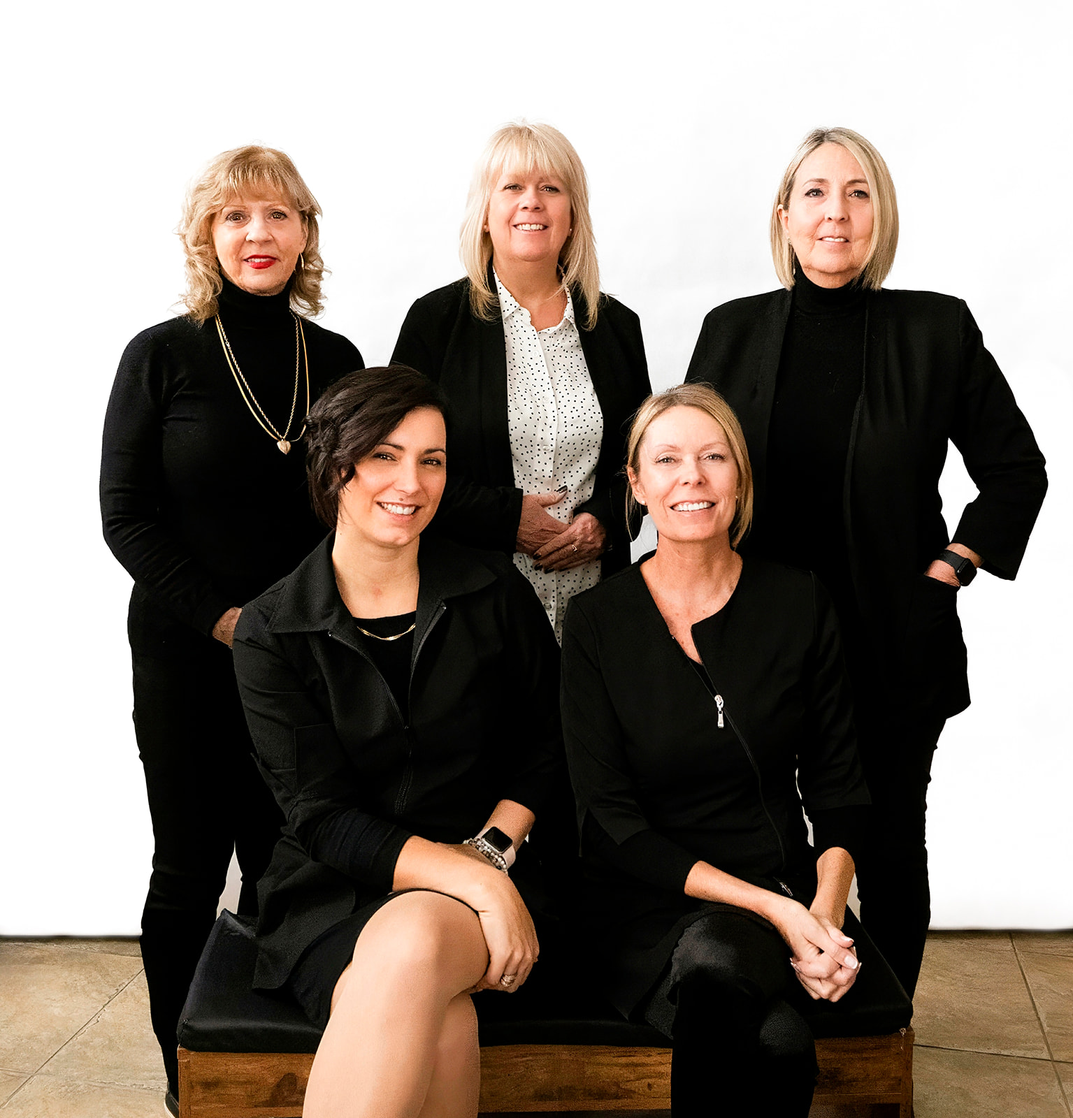 Équipe professionnelle de la clinique dentaire, cinq femmes posant ensemble.